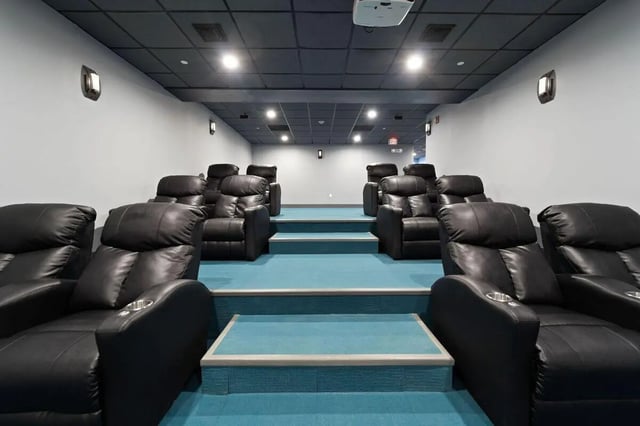 Black leather recliner chairs with cup holders cinema room at The Printing House in Binghamton Student Accommodation