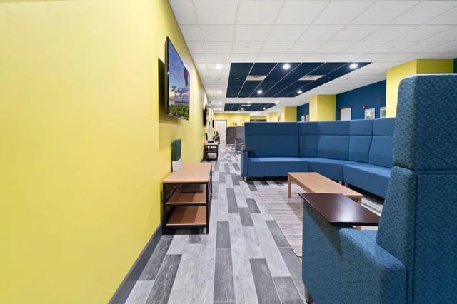 Blue sectional sofa television and tables common area at The Printing House in Binghamton Student Accommodation