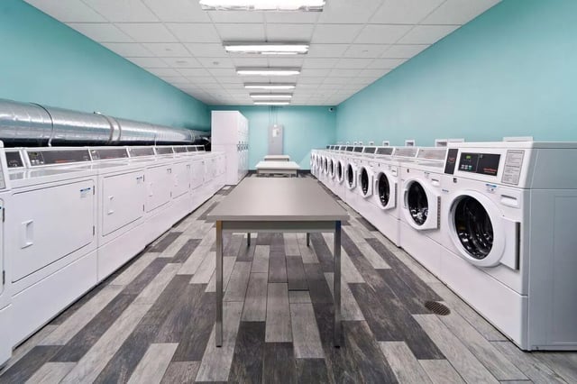Washers dryers tables and lockers laundry room at The Printing House in Binghamton Student Accommodation
