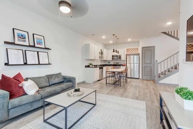 Sofa coffee table kitchen dining living area exterior at The Row At The Stadium in Columbia Student Accommodation
