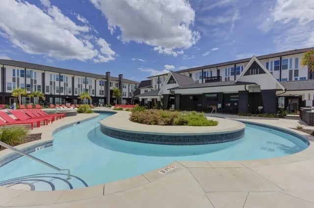 Pool with lounge chairs building exterior at The Row At The Stadium in Columbia Student Accommodation