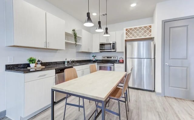 Dining table chairs stainless steel refrigerator kitchen at The Row At The Stadium in Columbia Student Accommodation