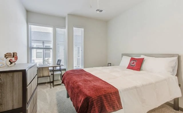 Bed desk dresser and windows bedroom at The Row At The Stadium in Columbia Student Accommodation