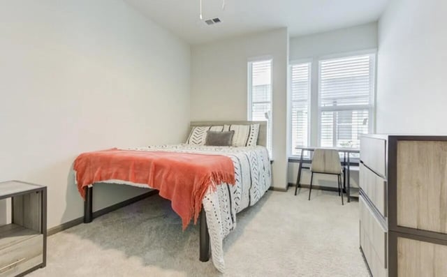 Bed dresser desk and chair bedroom at The Row At The Stadium in Columbia Student Accommodation