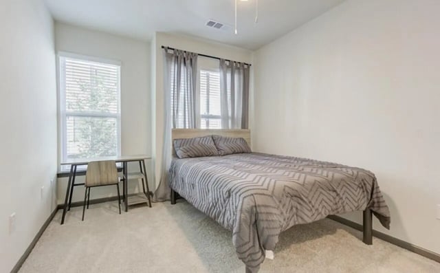 Bed desk chair window and bedding bedroom at The Row At The Stadium in Columbia Student Accommodation
