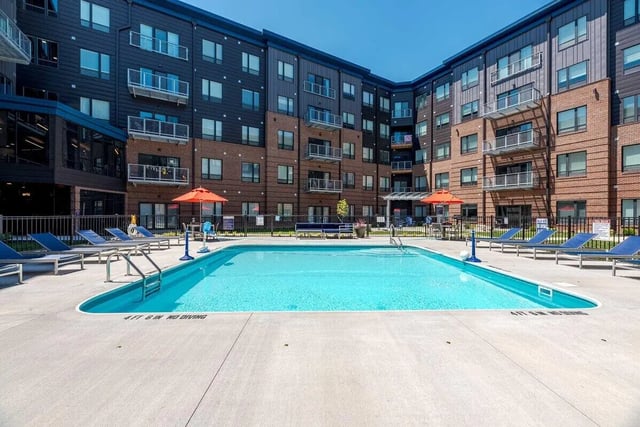 Swimming pool with lounge chairs and building exterior at The Flight at Dayton in Dayton Student Accommodation