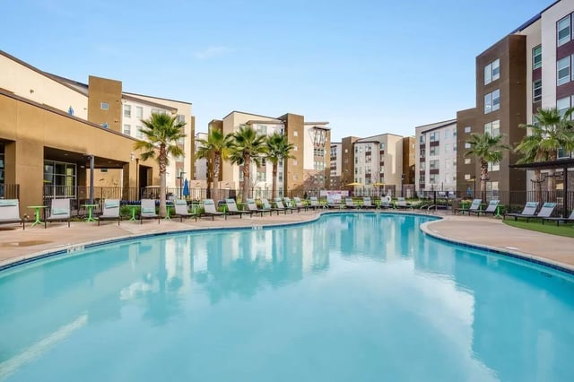 Pool lounge chairs and tables exterior at The Crossings Apartments in Sacramento Student Accommodation