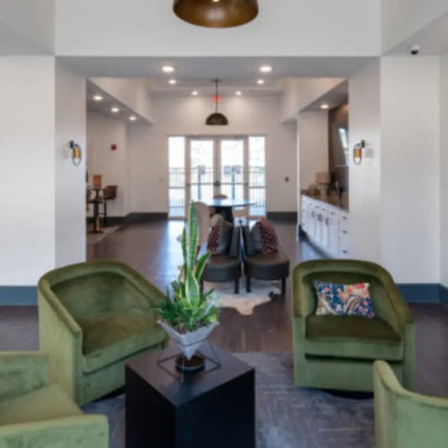 Green armchairs plant table and chairs communal area at Bellamy Daytona in Daytona Beach Student Accommodation