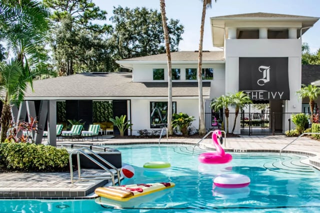 Pool with inflatable flamingo pizza and chairs exterior at The Ivy in Tampa Student Accommodation