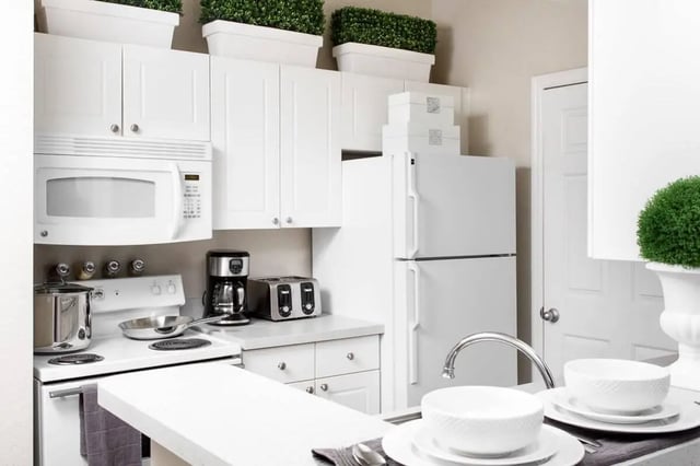 White cabinets microwave refrigerator toaster coffee maker kitchen at The Ivy in Tampa Student Accommodation