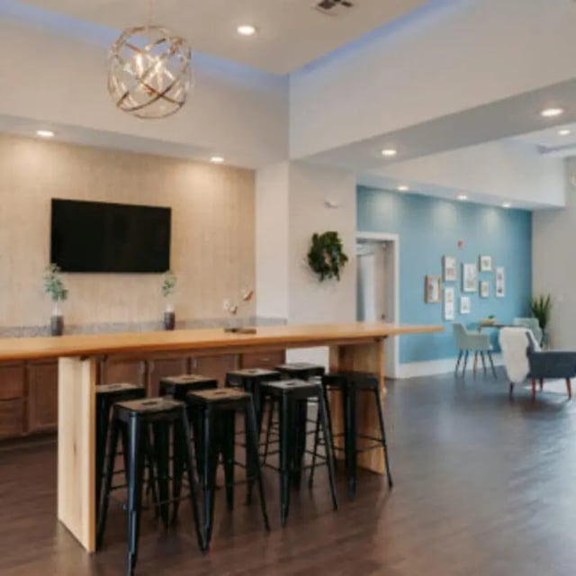 Bar stools and long counter with TV living area at Bellamy Florence in Florence Student Accommodation