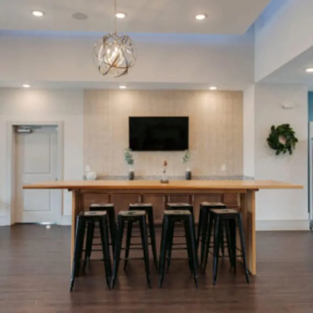 Long table with stools and television lounge at Bellamy Florence in Florence Student Accommodation