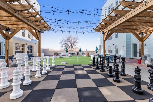 Giant chess pieces on checkerboard patio and grassy area outdoor area at Canyon Flats in Reno Student Accommodation
