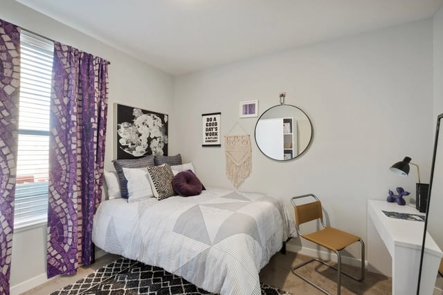 Bed with patterned bedding desk mirror and chair bedroom at Canyon Flats in Reno Student Accommodation