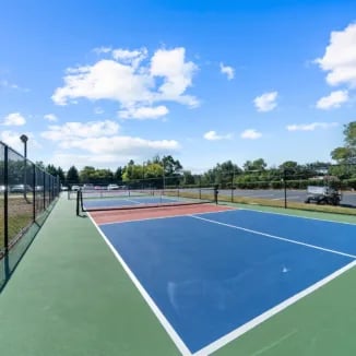 Tennis court with blue and green surface exterior at Bellamy Milledgeville in Milledgeville Student Accommodation