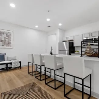 Modern kitchen island with white bar stools living area kitchen at Bellamy Milledgeville in Milledgeville Student Accommodation