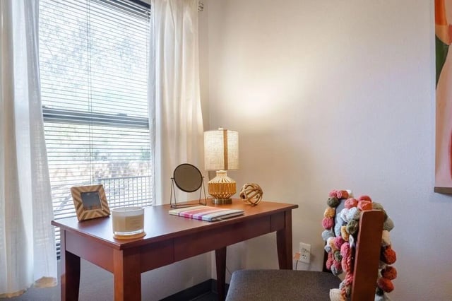 Desk with lamp mirror candle and chair study area at Claremont Collegiate Apartments