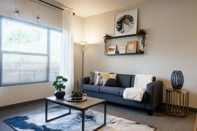 Dark grey sofa coffee table art living room at Claremont Collegiate Apartments