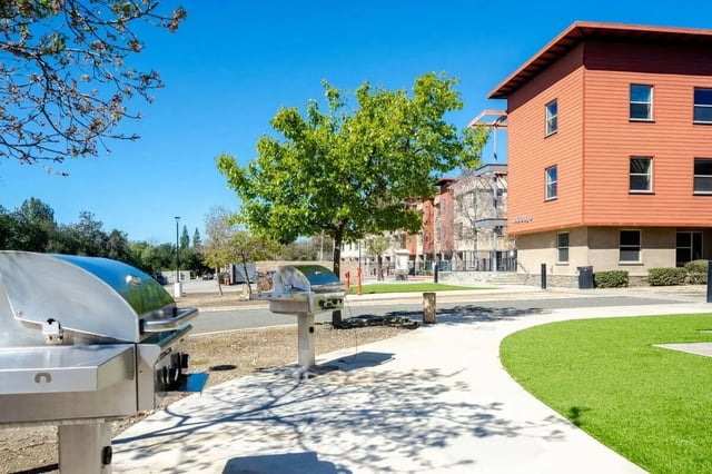 Two stainless steel grills near building exterior at Claremont Collegiate Apartments