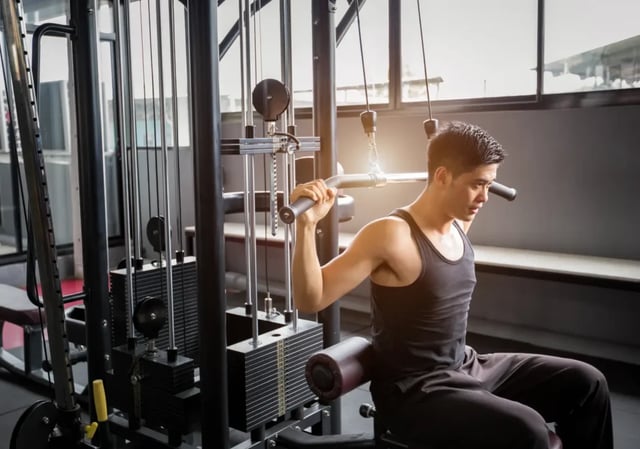 Man exercising on weight machine gym area at 626 on the Park in Chicago Student Accommodation