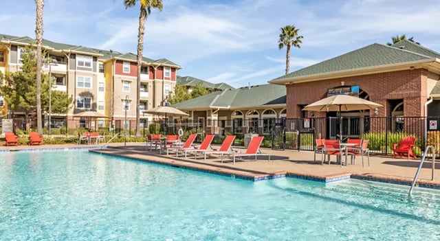 Pool with lounge chairs and tables exterior at The U Apartments in Davis Student Accommodation