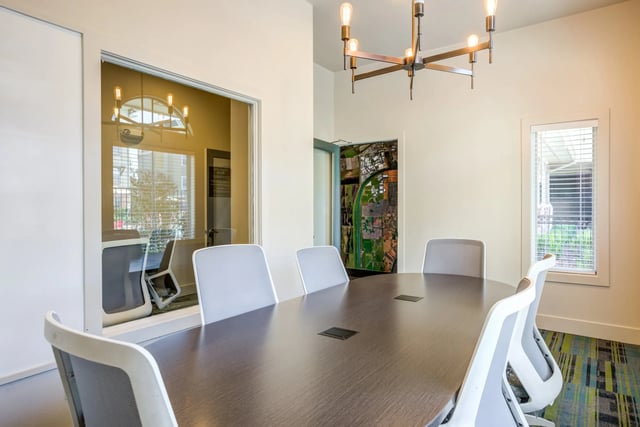 Conference table and chairs in a modern meeting room at The U Apartments in Davis Student Accommodation