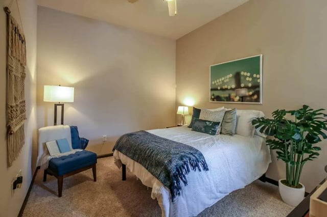 Bed desk chair wall art and plant bedroom at Crimson in Tuscaloosa Student Accommodation