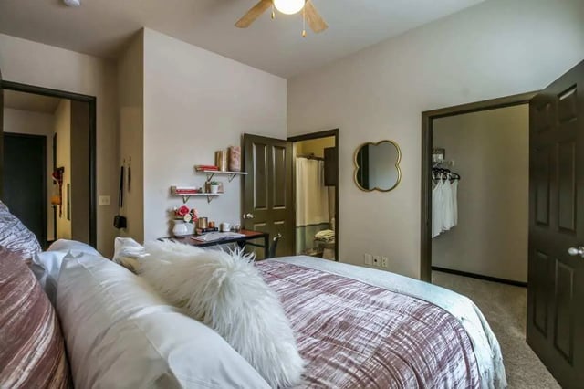 Bed with pillows and desk with books Bedroom at Crimson in Tuscaloosa Student Accommodation