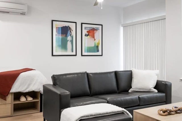 Sofa bed artwork and air conditioner living room at UNITi Bishop Arts in Dallas Student Accommodation