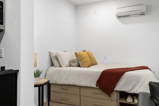 Bed with storage drawers and pillows bedroom at UNITi Bishop Arts in Dallas Student Accommodation