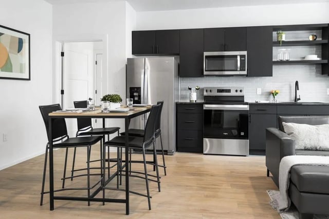 Dining table four chairs stainless steel refrigerator kitchen living room at UNITi Bishop Arts in Dallas Student Accommodation