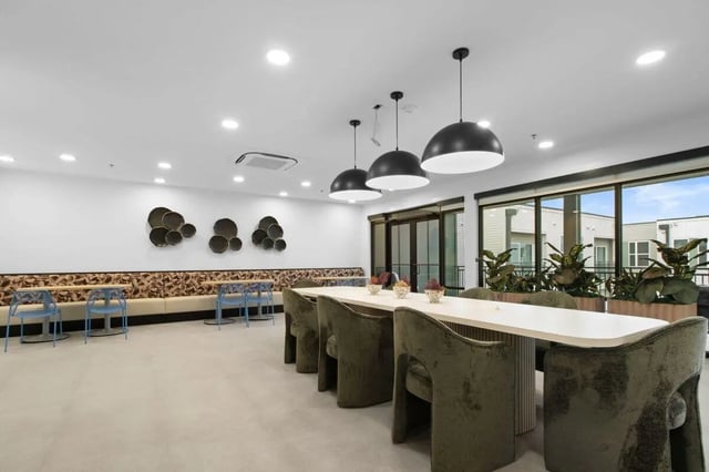 long table with plush chairs communal seating area at UNITi Bishop Arts in Dallas Student Accommodation