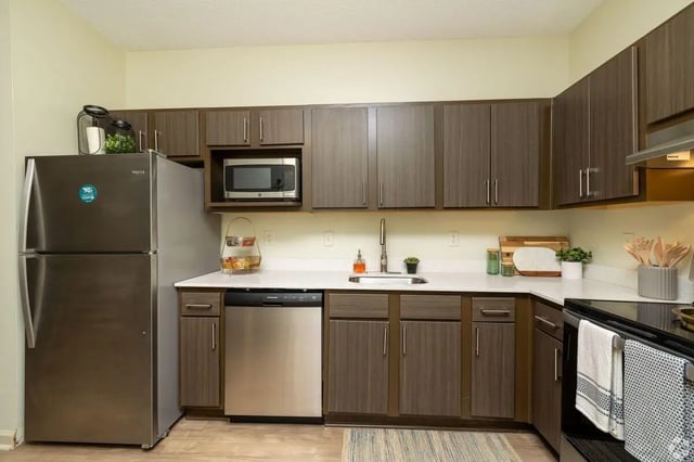 Stainless steel appliances wood cabinets and quartz counters Kitchen at Clemson Edge in Clemson Student Accommodation