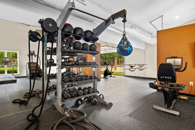 Dumbbells medicine balls punching bag exercise bike gym area at Clemson Edge in Clemson Student Accommodation