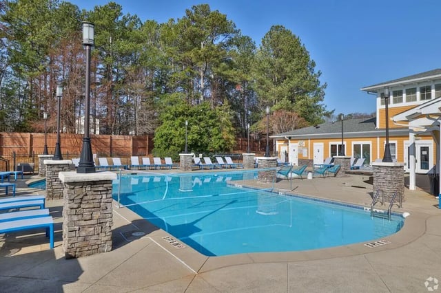 Swimming pool with lounge chairs and building exterior at Clemson Edge in Clemson Student Accommodation