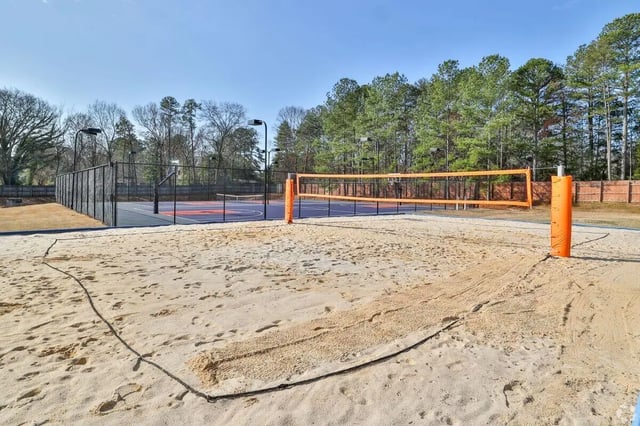 Beach volleyball court with tennis court beyond playing area at Clemson Edge in Clemson Student Accommodation