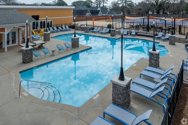 Pool with lounge chairs tables and volleyball court exterior at Clemson Edge in Clemson Student Accommodation