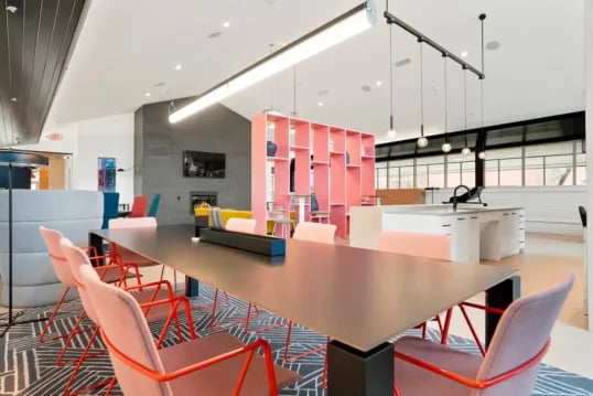Large table pink chairs modern lounge area at The Province Boulder in Boulder Student Accommodation