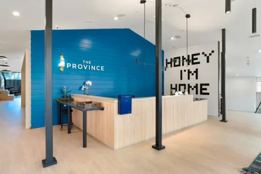 Blue reception desk with wooden accents reception area at The Province Boulder in Boulder Student Accommodation