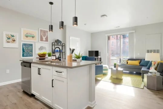 Kitchen island with sink and living area living room at The Province Boulder in Boulder Student Accommodation