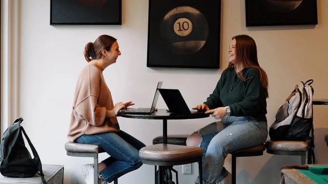 Two women with laptops at table study area at Copper Beech at Ames Apartments in Ames Student Accommodation
