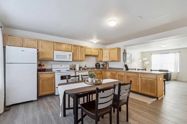 White refrigerator stove microwave island kitchen table kitchen at Copper Beech at Ames Apartments in Ames Student Accommodation