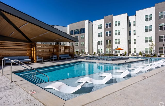 Pool with lounge chairs and building exterior at The Davy in Knoxville Student Accommodation