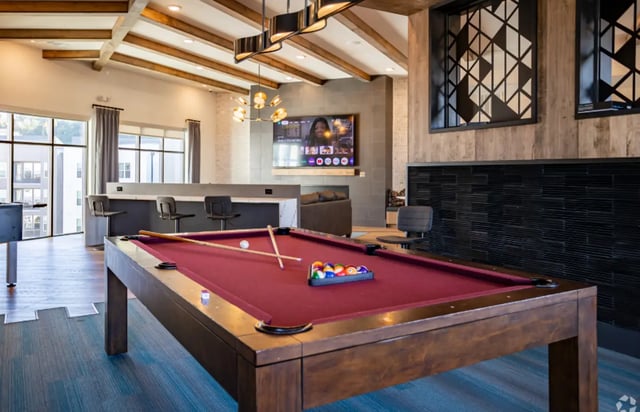 Pool table with balls cues and seating area game room at The Davy in Knoxville Student Accommodation