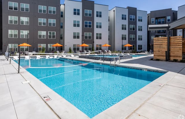 Swimming pool volleyball net orange umbrellas and lounge chairs exterior at The Davy in Knoxville Student Accommodation