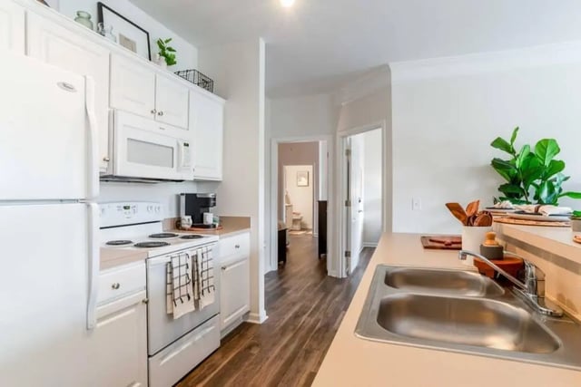 White appliances cabinets microwave sink and flooring kitchen at The Province Greensboro in Greensboro Student Accommodation