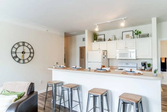 Bar stools and kitchen with white cabinets kitchen at The Province Greensboro in Greensboro Student Accommodation