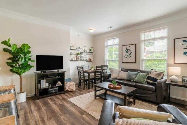 Dark leather sofa dining table with chairs living room at The Province Greensboro in Greensboro Student Accommodation