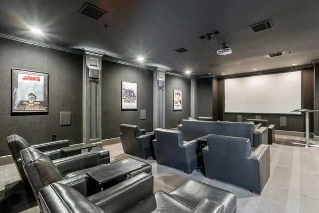 Leather chairs and sofas facing a large screen cinema room at The Province Greensboro in Greensboro Student Accommodation