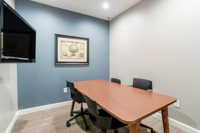 Conference table with chairs and wall mounted TV study area at The Province Greensboro in Greensboro Student Accommodation